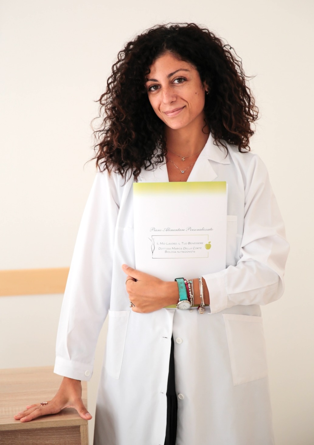 La dottoressa Marica Della Corte, biologa nutrizionista, in camice bianco con un piano alimentare personalizzato tra le mani